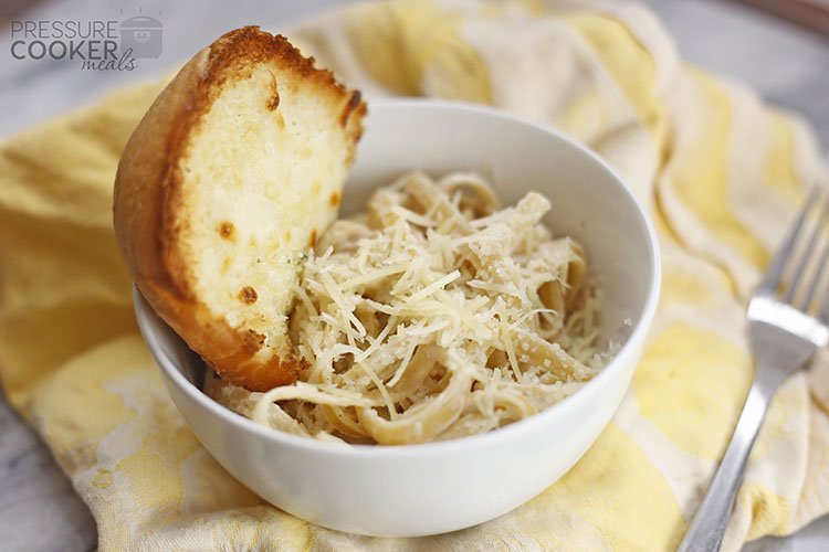 White Bowl of Instant Pot Chicken Alfredo with Garlic Bread on yellow cloth