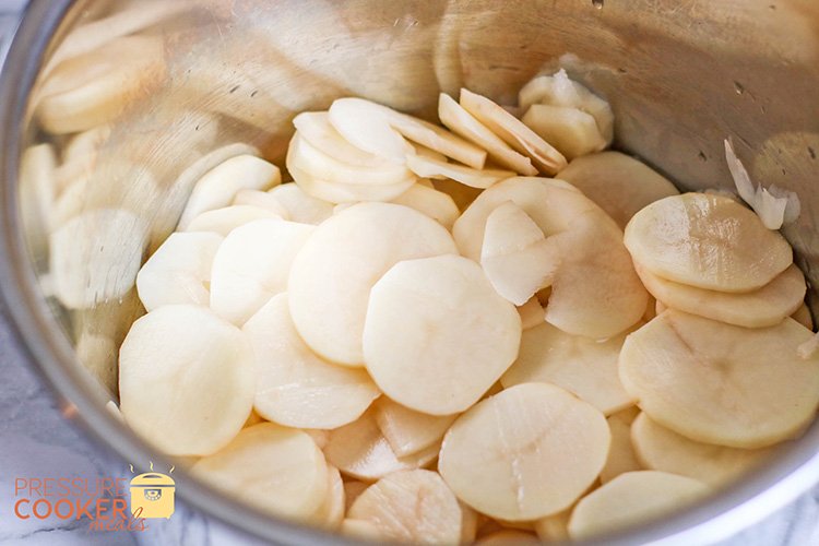Sliced potatoes in pot for Easy Instant Pot Au Gratin Potatoes